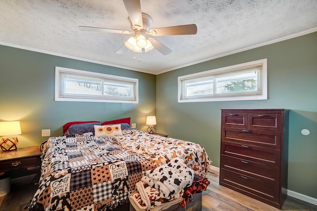 bedroom with a textured ceiling, crown molding, ceiling fan, and light hardwood / wood-style flooring