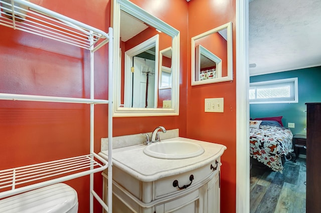 bathroom featuring toilet, hardwood / wood-style flooring, a textured ceiling, and vanity