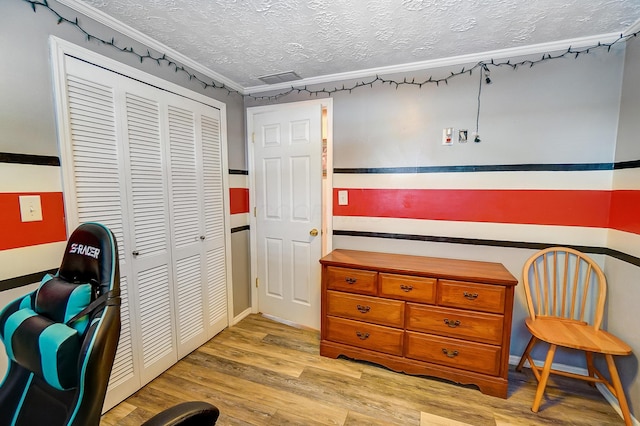 misc room with light wood-type flooring and a textured ceiling