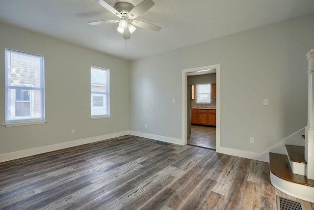 empty room with dark hardwood / wood-style flooring and ceiling fan