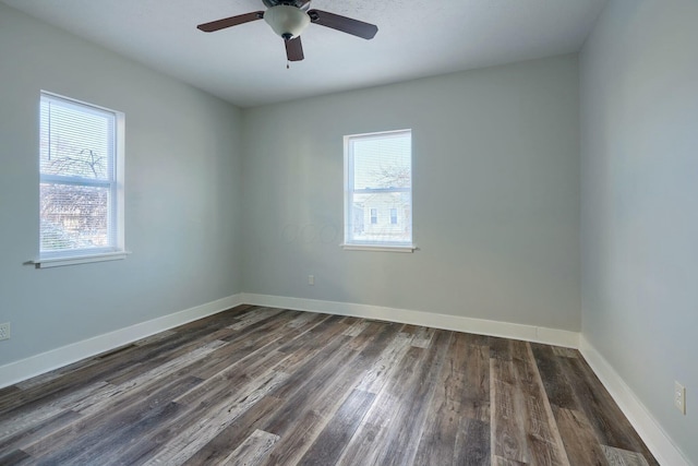 unfurnished room with ceiling fan, dark wood-type flooring, and a wealth of natural light