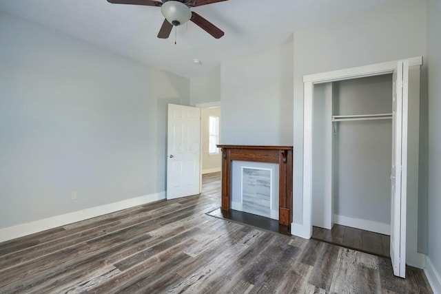 unfurnished bedroom with dark wood-type flooring, ceiling fan, and a closet