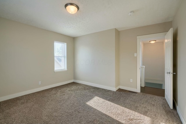 empty room featuring carpet floors and a textured ceiling