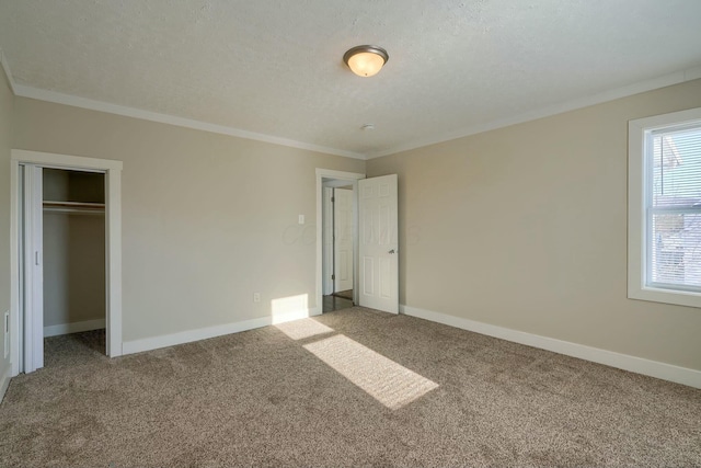 unfurnished bedroom featuring carpet floors, crown molding, a textured ceiling, and a closet