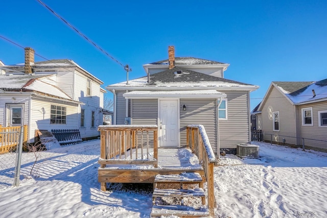 snow covered property with central AC unit