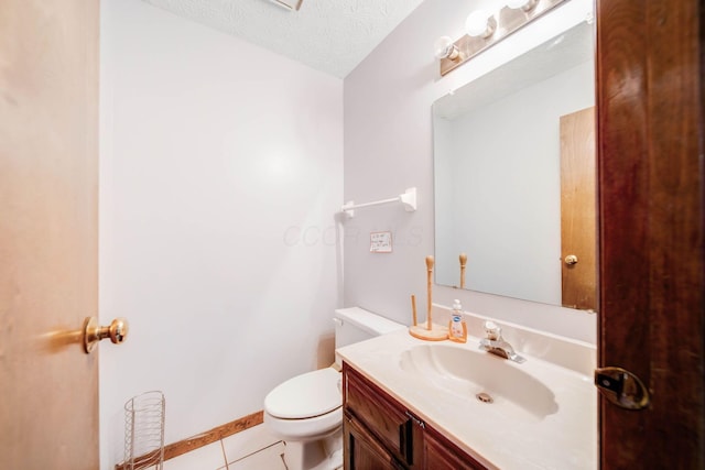 bathroom with baseboards, toilet, tile patterned floors, a textured ceiling, and vanity