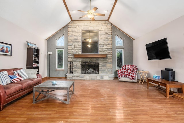 living room with a ceiling fan, a fireplace, high vaulted ceiling, and wood finished floors