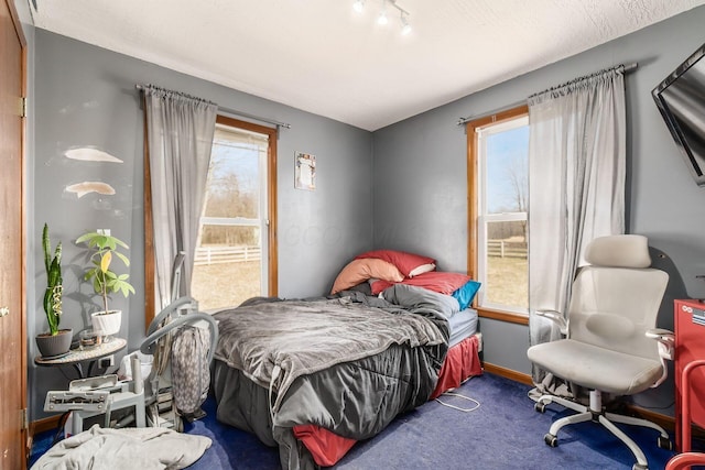 carpeted bedroom featuring baseboards