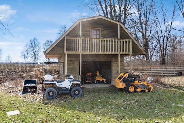 view of outdoor structure featuring a garage, an outbuilding, and fence