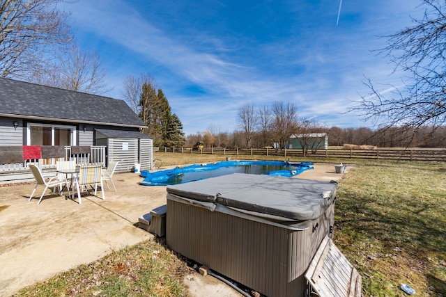 view of swimming pool with an outbuilding, a fenced backyard, a storage unit, a patio area, and a hot tub