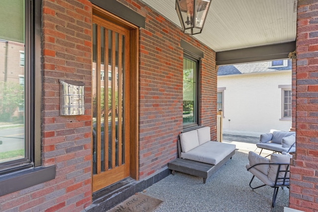 doorway to property with covered porch and brick siding