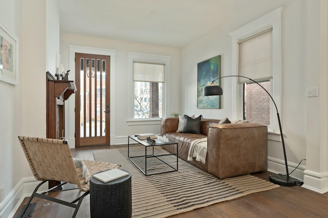 living room with wood finished floors, visible vents, and baseboards