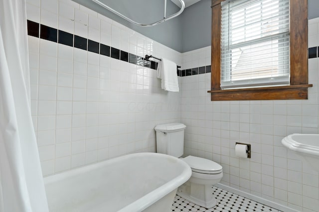 full bath with curtained shower, tile patterned flooring, toilet, a washtub, and tile walls