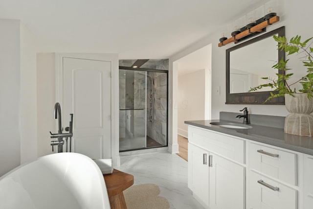 bathroom featuring a stall shower, marble finish floor, a freestanding tub, and vanity