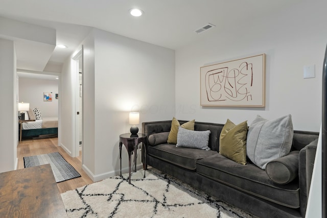 living area featuring baseboards, wood finished floors, visible vents, and recessed lighting