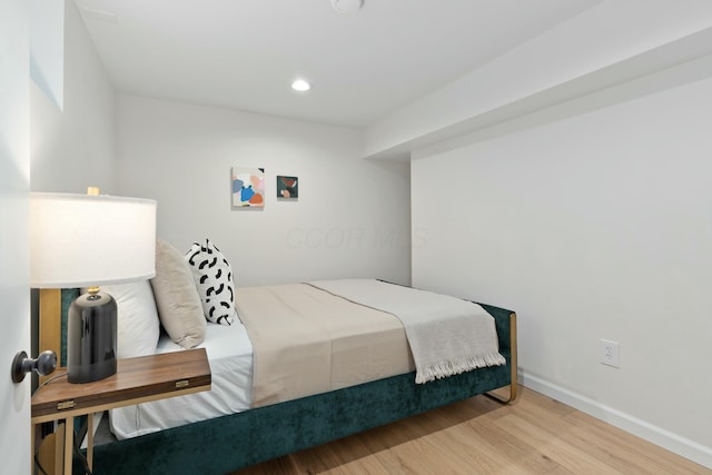 bedroom featuring baseboards, wood finished floors, and recessed lighting