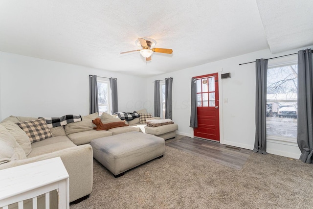 living room featuring ceiling fan, a textured ceiling, a wealth of natural light, and hardwood / wood-style floors