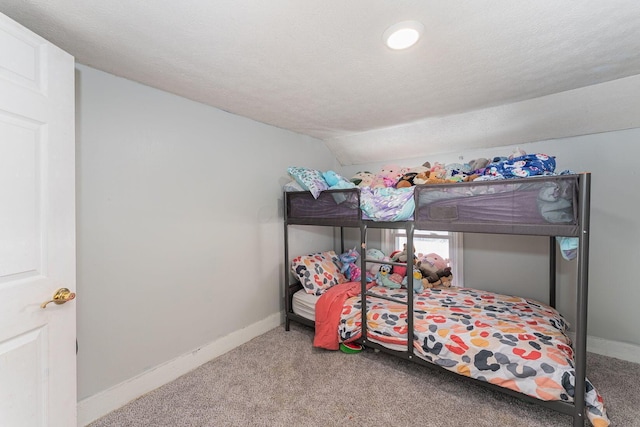 carpeted bedroom featuring a textured ceiling and lofted ceiling