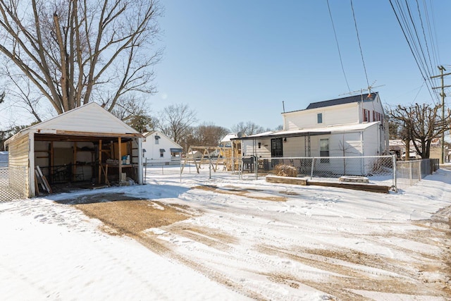 yard covered in snow featuring covered porch and an outdoor structure