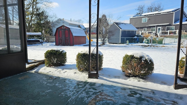 snowy yard with a storage shed