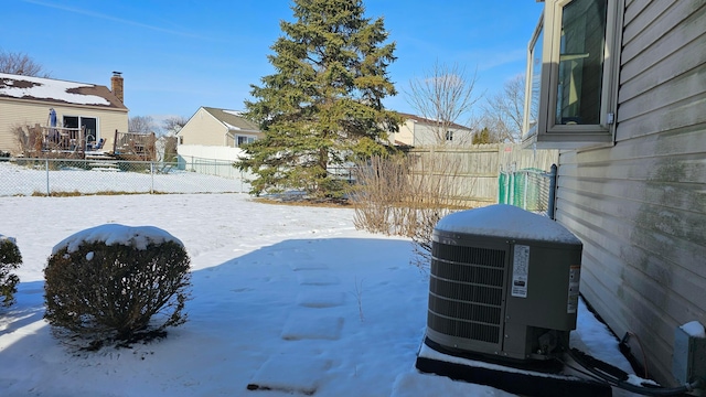 yard layered in snow featuring central air condition unit