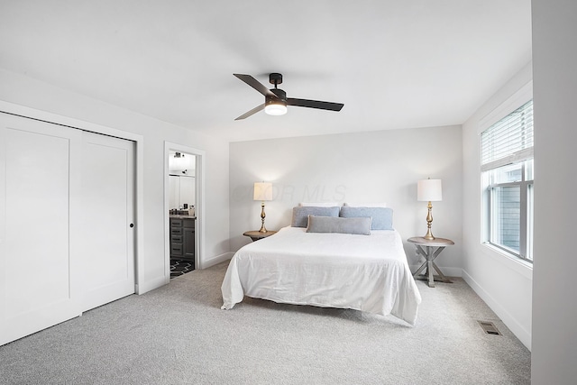 bedroom with ensuite bathroom, ceiling fan, and carpet flooring