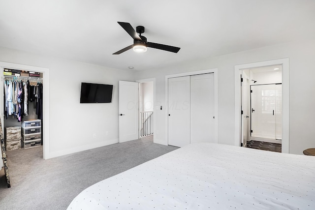 bedroom with ensuite bath, ceiling fan, dark carpet, a walk in closet, and a closet