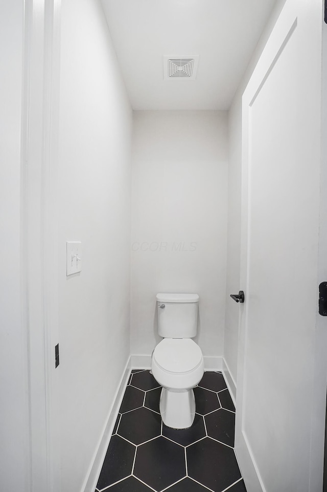 bathroom featuring toilet and tile patterned flooring