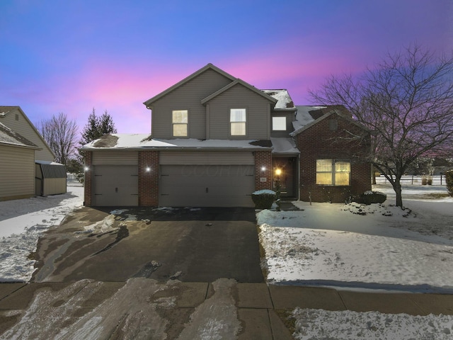 traditional-style house featuring driveway, brick siding, and an attached garage