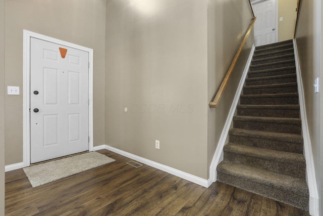 foyer featuring visible vents, dark wood finished floors, and baseboards