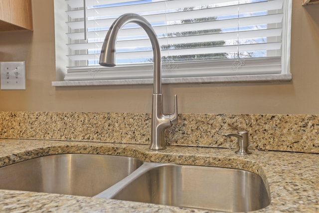 room details with a sink and light stone countertops