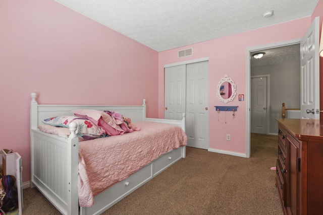 bedroom with a textured ceiling, carpet floors, visible vents, baseboards, and a closet