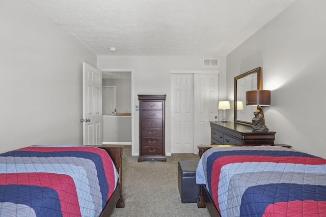 bedroom with baseboards, visible vents, dark colored carpet, a textured ceiling, and a closet