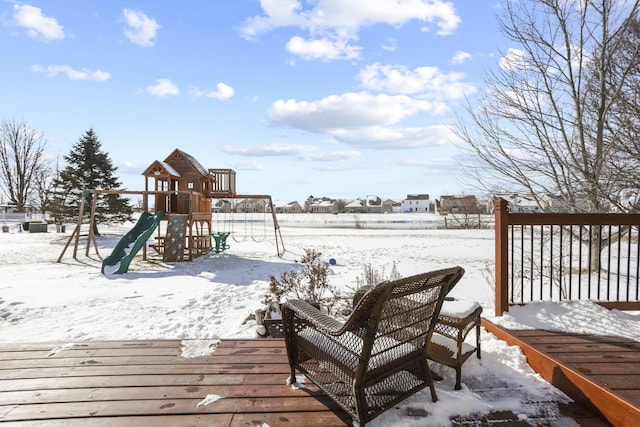 snow covered deck featuring a playground