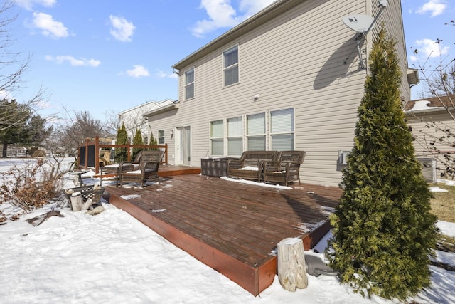 snow covered rear of property featuring a deck