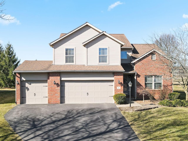 traditional-style home with driveway, brick siding, a front lawn, and a shingled roof