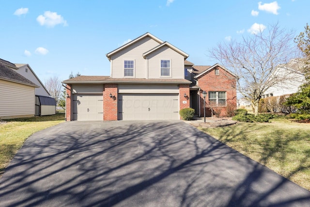 traditional-style house featuring driveway, brick siding, and a front yard