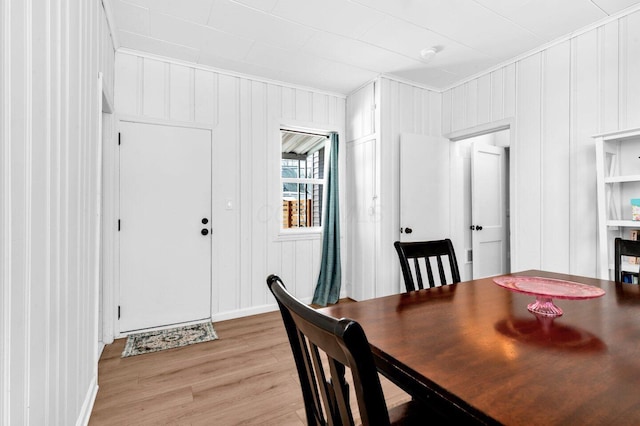 dining space with light hardwood / wood-style floors and crown molding