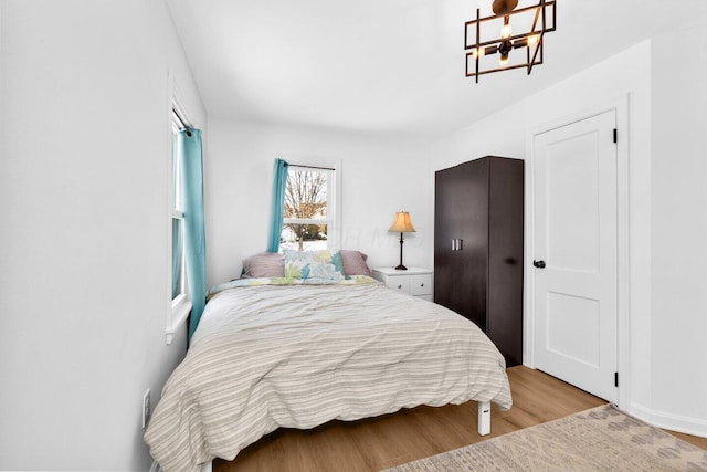 bedroom featuring light hardwood / wood-style flooring and a chandelier