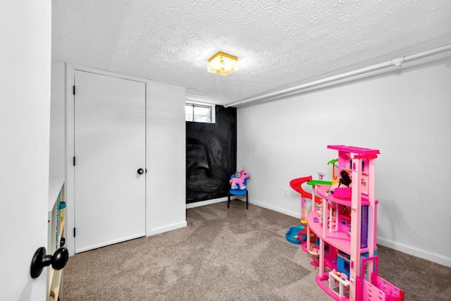 rec room featuring carpet floors and a textured ceiling