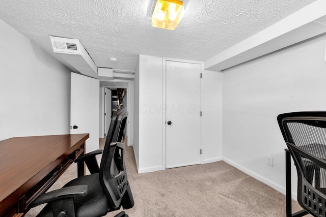 carpeted office space with a textured ceiling