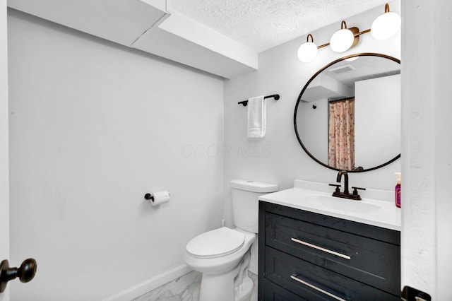 bathroom with a textured ceiling, toilet, and vanity