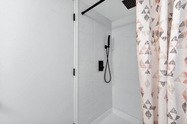 bathroom with a textured ceiling and a shower with shower curtain