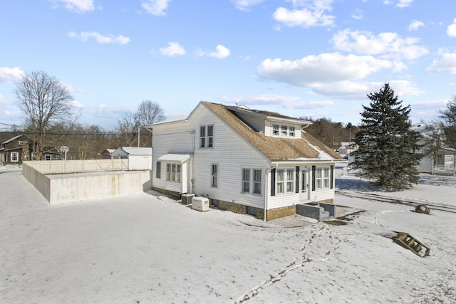 exterior space with central AC unit and a sunroom