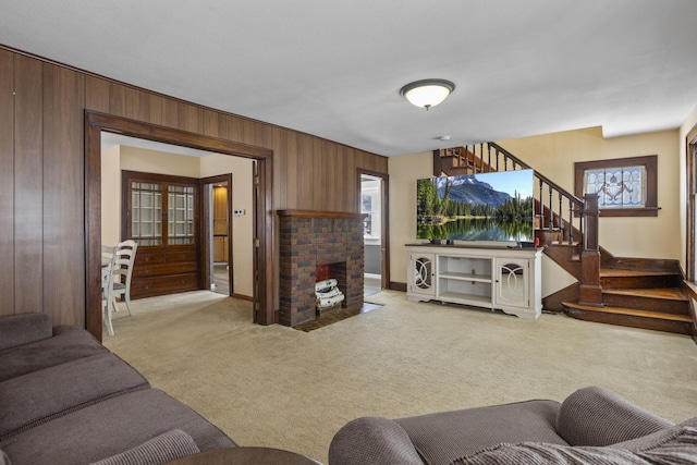 living room featuring wood walls, light colored carpet, and a fireplace