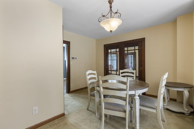 carpeted dining space with french doors