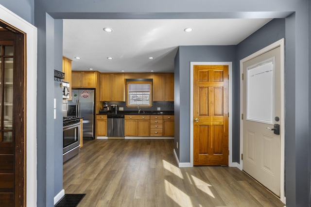 kitchen with sink, appliances with stainless steel finishes, and dark hardwood / wood-style floors