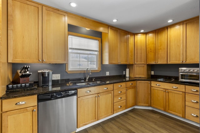 kitchen with dark stone countertops, dishwasher, dark wood-type flooring, and sink