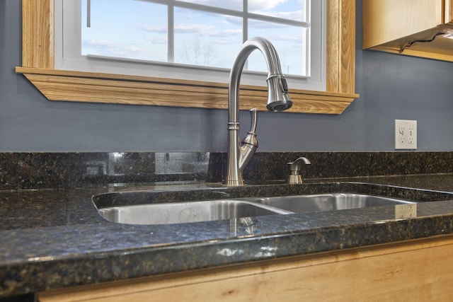 details featuring dark stone countertops and sink