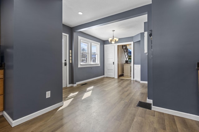 foyer featuring hardwood / wood-style floors and a chandelier